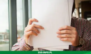 Mężczyzna w kratę trzyma dokumenty, być może wniosek o niezaleganie ZUS.