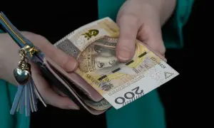 Ręce trzymają portfel z banknotami 200 zł. Ile wynosi rodzinne wsparcie?
