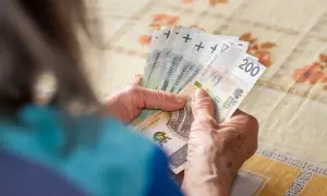 Dłonie starszej osoby liczą banknoty, być może oczekując na czternastą emeryturę.